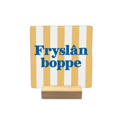 Fryslân boppe - Decoratie tegel - Formaat: - Op deze decoratie tegel staat de tekst "Fryslân boppe" in blauwe letters centraal afgebeeld. De achtergrond is voorzien van een verticaal gestreept patroon in de kleuren geel en wit. - Snelwenskaart