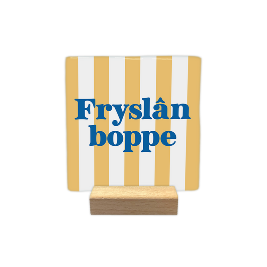 Fryslân boppe - Decoratie tegel - Formaat: - Op deze decoratie tegel staat de tekst "Fryslân boppe" in blauwe letters centraal afgebeeld. De achtergrond is voorzien van een verticaal gestreept patroon in de kleuren geel en wit. - Snelwenskaart