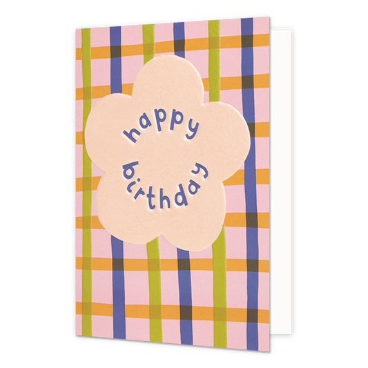 Happy birthday - Formaat: Normaal - Vorm: Staand - Verjaardagskaart - Op deze wenskaart staat in het midden een grote, lichtroze bloemvorm. Binnenin de bloem staat de tekst "happy birthday" in paarse, speelse letters die de ronde vorm van de bloem volgen. De achtergrond van de kaart bestaat uit een kleurrijk ruitpatroon met verticale en horizontale banen in de kleuren roze, geel, groen en paars. - Snelwenskaart