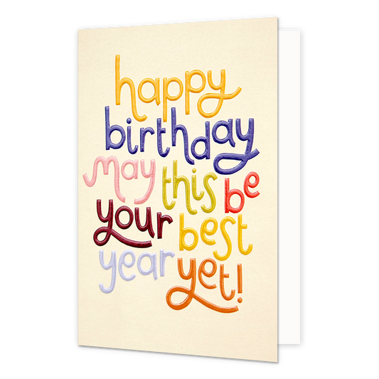 Happy birthday - Formaat: Normaal - Vorm: Staand - Verjaardagskaart - Op deze wenskaart staat de tekst "happy birthday may this be your best year yet!" centraal tegen een lichtbeige achtergrond. De woorden zijn uitgevoerd in een speels, handgeschreven lettertype waarbij elke regel of elk woord een andere kleur heeft, zoals geel, blauw, roze, groen, rood, paars en oranje. De letters lijken een licht reliëf of een geborduurd effect te hebben, wat de kaart een tactiele uitstraling geeft. - Snelwenskaart