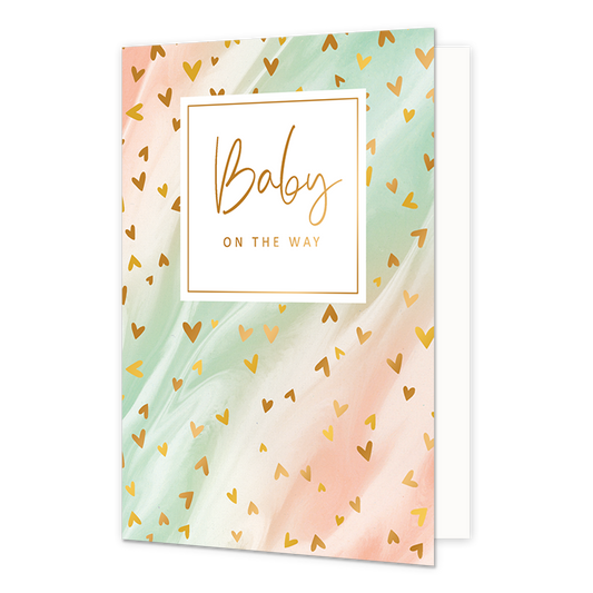 Baby on the way - Formaat: Normaal - Vorm: Staand - Zwanger kaart - Op deze artistieke wenskaart is een ontwerp te zien met de kleuren roze, beige en groen, waar kleine gouden hartjes op zitten. In het midden zit een wit blok met de gouden tekst "Baby on the way". - Snelwenskaart