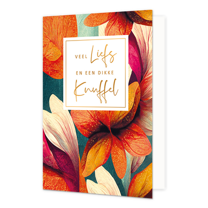 Veel liefs en een dikke knuffel - Formaat: Standaard - Vorm: Staand - Denken aan kaart - Op deze wenskaart staat een artistieke, botanische illustratie van grote bloemen in levendige kleuren zoals oranje, felroze en wit tegen een donkere achtergrond. De bloemblaadjes zijn gedetailleerd weergegeven met fijne texturen en goudkleurige spikkels. In het midden bevindt zich een wit vierkant kader met een gouden rand waarin de tekst "VEEL Liefs EN EEN DIKKE Knuffel" staat geschreven. De woorden "Liefs" en "Knuffe