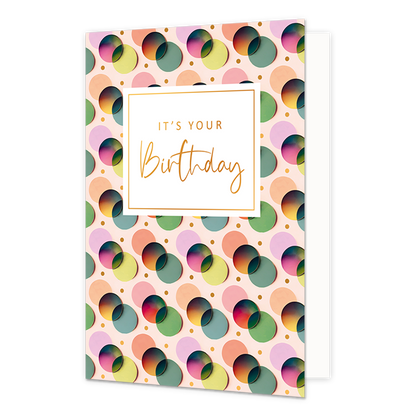 It's your birthday - Formaat: Normaal - Vorm: Staand - Verjaardagskaart - Op deze wenskaart zijn stippen te zien in de kleuren lila, orangje, groen, blauw en rood. In het midden zit een wit blok met de gouden tekst: "It's your birthday". - Snelwenskaart