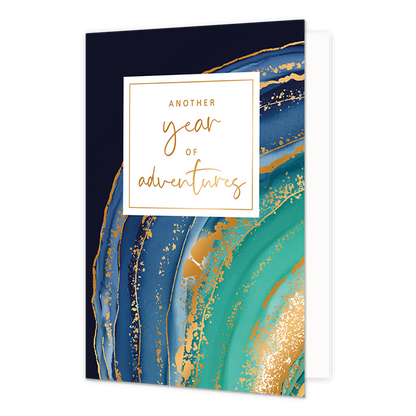 Another year of adventures - Formaat: Normaal - Vorm: Staand - Verjaardagskaart - Op deze wenskaart is een ontwerp te zien met de kleuren blauw, groen en goud. In het midden zit een wit blok met de gouden tekst: "Another year of adventures". - Snelwenskaart