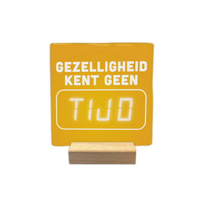 Gezelligheid kent geen tijd - Decoratie tegel - Formaat: - Op deze decoratie tegel staat bovenaan de tekst "Gezelligheid kent geen" in witte letters. Daaronder bevindt zich een wit kader met daarin het woord "tijd" in een digitale klokstijl. De achtergrond van de tegel is geel. - Snelwenskaart
