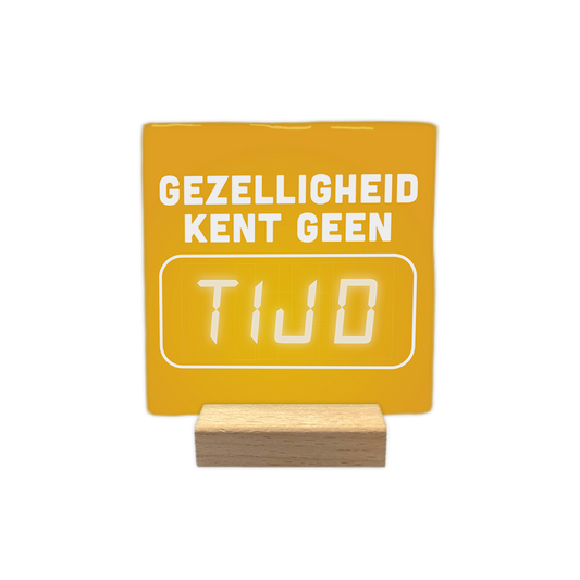 Gezelligheid kent geen tijd - Decoratie tegel - Formaat: - Op deze decoratie tegel staat bovenaan de tekst "Gezelligheid kent geen" in witte letters. Daaronder bevindt zich een wit kader met daarin het woord "tijd" in een digitale klokstijl. De achtergrond van de tegel is geel. - Snelwenskaart
