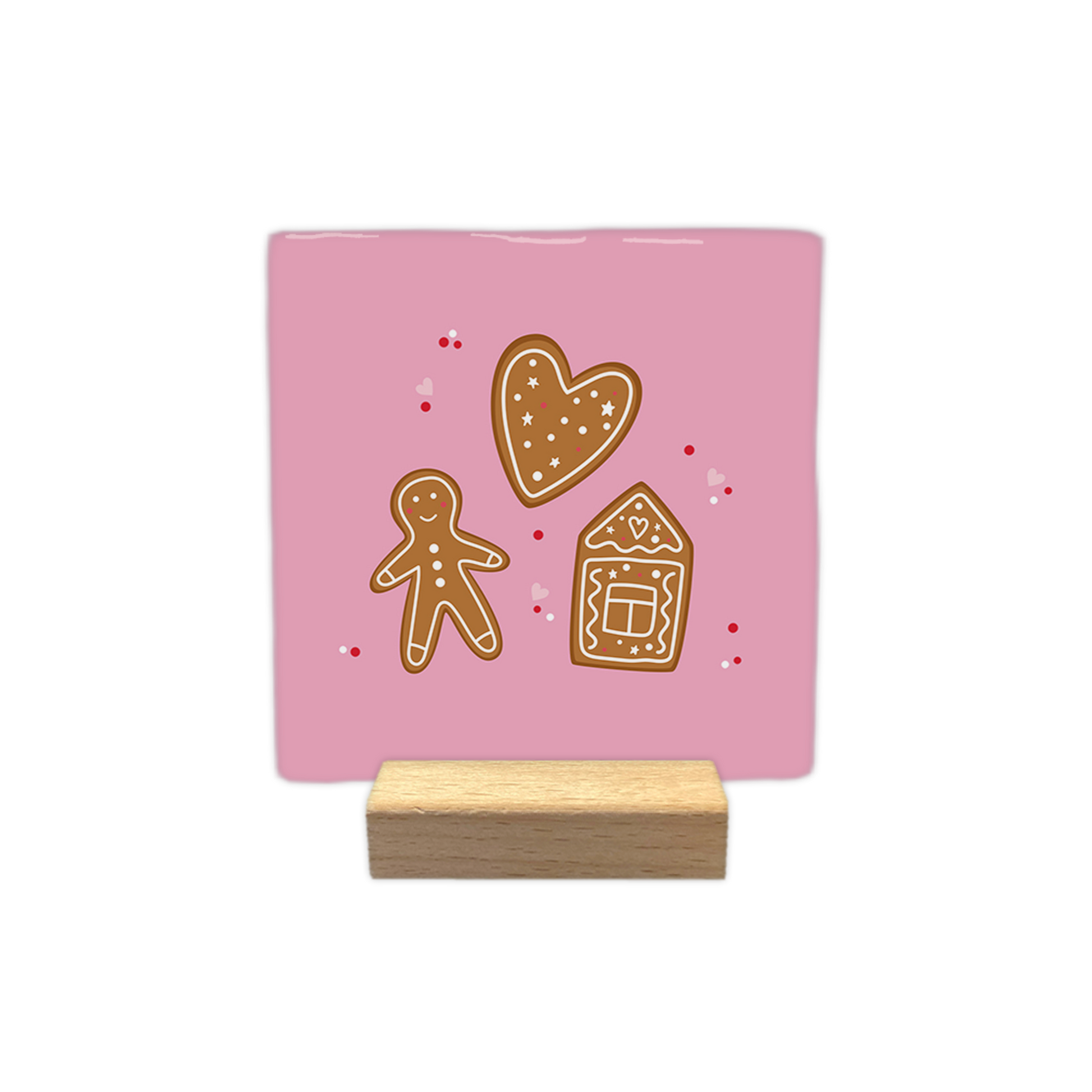 Gingerbread - Decoratie tegel - Op deze decoratietegel staat een illustratie van drie peperkoekfiguren tegen een lichtroze achtergrond: een hart, een peperkoekmannetje en een peperkoekhuisje, alle voorzien van witte decoratieve details. Rondom de figuren zijn kleine rode stippen en roze hartjes afgebeeld. - Snelwenskaart
