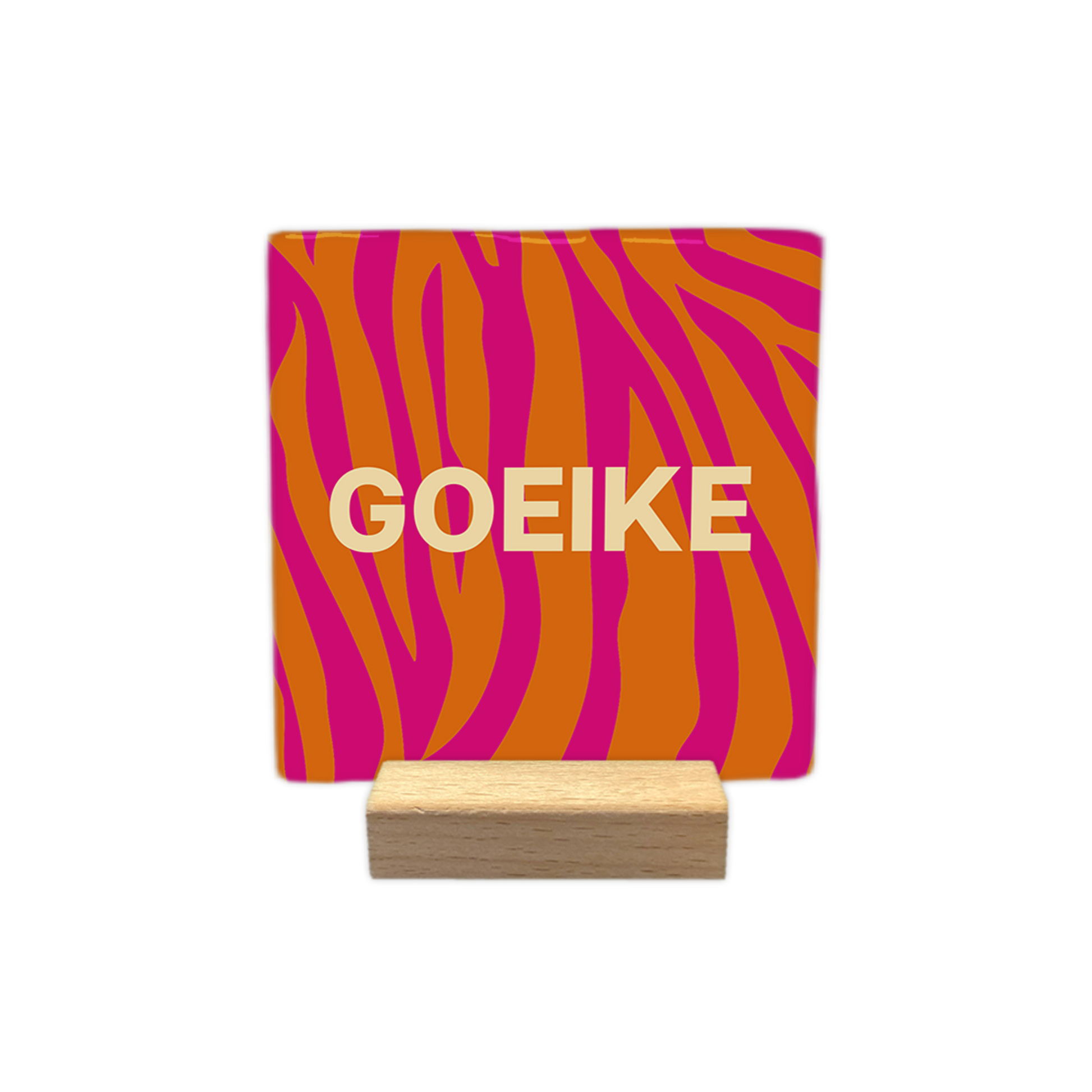 Goeike - Decoratie tegel - Formaat: - Op deze decoratie tegel staat het woord "goeike" centraal afgebeeld in crèmekleurige letters. De achtergrond van de tegel bestaat uit een opvallend patroon van oranje en roze tijgerstrepen. - Snelwenskaart