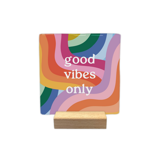 Good vibes only - Decoratie tegel - Formaat: - Op deze decoratietegel staat in het midden de Engelse tekst "good vibes only". De tegel zelf is vierkant, staat in een houten standaard en heeft een kleurrijke, psychedelische achtergrond met golvende banen in onder andere rood, oranje, geel, roze, lila, blauw en groen.&nbsp;L - Snelwenskaart