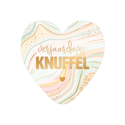 Verjaardagsknuffel - Formaat: Standaard - Vorm: Hart - Verjaardagskaart - Op deze harten wenskaart is een abstracte achtergrond te zien met vloeiende lijnen in pastelkleuren zoals zachtgroen, roze en geel. De tekst "verjaardags KNUFFEL" staat centraal in een combinatie van een sierlijk en een strak lettertype. Het ontwerp bevat subtiele goudkleurige spikkels en lijnen die door het patroon lopen. Onder de tekst bevindt zich een klein, effen goudkleurig icoon. - Snelwenskaart