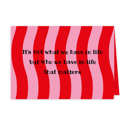 Who we have in life - Formaat: Klein - Vorm: Liggend - Vriendschapskaart - Op deze wenskaart zijn roze en rode lijnen te zien met in het midden de tekst: "It's not what we have in life but who we have in life that matters". - Snelwenskaart