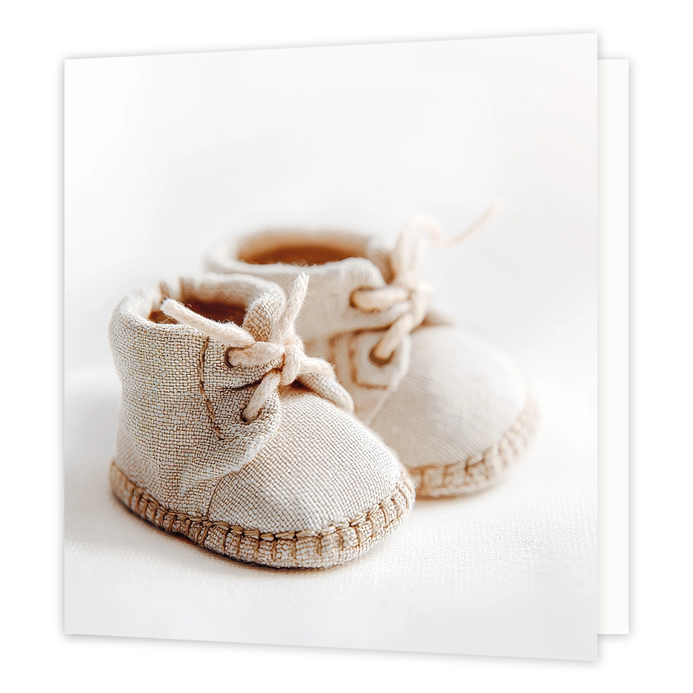Babyschoentjes - Formaat: Standaard - Vorm: Vierkant - Geboortekaart - Op deze wenskaart staat een illustratie van twee beige, stoffen babyschoentjes die dicht bij elkaar op een lichte ondergrond zijn geplaatst. De schoentjes zijn voorzien van veters die gestrikt zijn en hebben een grove stikrand rondom de zool. Er is geen tekst op de illustratie te zien. - Snelwenskaart