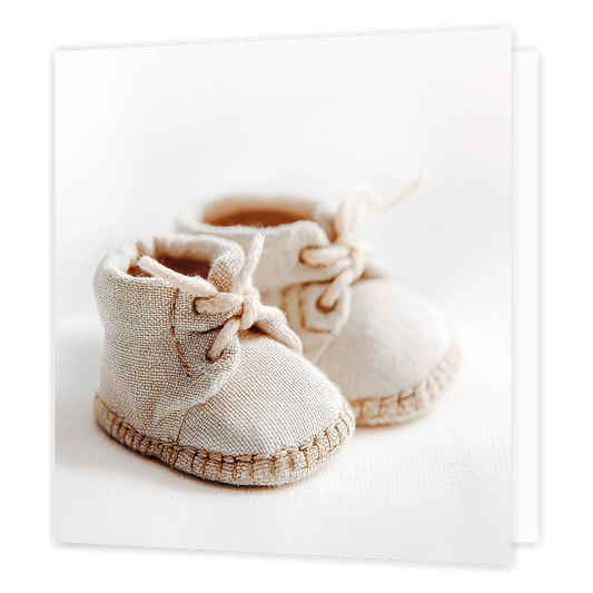 Babyschoentjes - Formaat: Standaard - Vorm: Vierkant - Geboortekaart - Op deze wenskaart staat een illustratie van twee beige, stoffen babyschoentjes die dicht bij elkaar op een lichte ondergrond zijn geplaatst. De schoentjes zijn voorzien van veters die gestrikt zijn en hebben een grove stikrand rondom de zool. Er is geen tekst op de illustratie te zien. - Snelwenskaart