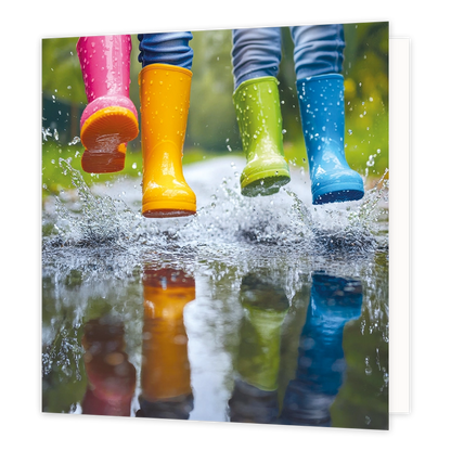 Waterplassen - Formaat: Standaard - Vorm: Vierkant - Blanco kaart - Op deze wenskaart staat een illustratie van vier gekleurde regenlaarzen in de kleuren roze, geel, groen en blauw. De laarzen behoren tot personen die door een plas water springen, wat zorgt voor opspattend water en regendruppels rondom de benen. In het water beneden is een duidelijke weerspiegeling van de gekleurde laarzen te zien. Er is geen tekst op de illustratie zichtbaar. - Snelwenskaart