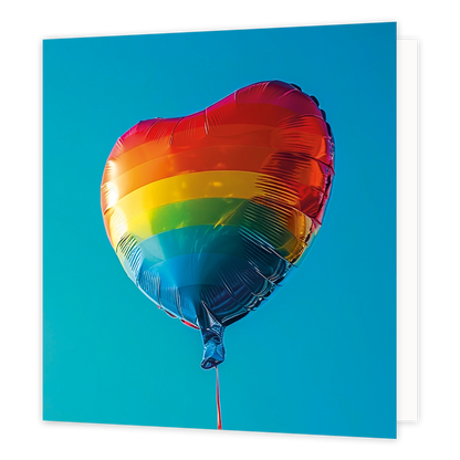 Regenboog ballon - Formaat: Standaard - Vorm: Vierkant - Blanco kaart - Op deze wenskaart staat een illustratie van een glanzende, hartvormige folieballon met de kleuren van een regenboog. De ballon hangt centraal tegen een egale, helderblauwe achtergrond. Aan de onderzijde van de ballon is een smal rood lintje zichtbaar. Er is geen tekst op de illustratie te zien. - Snelwenskaart