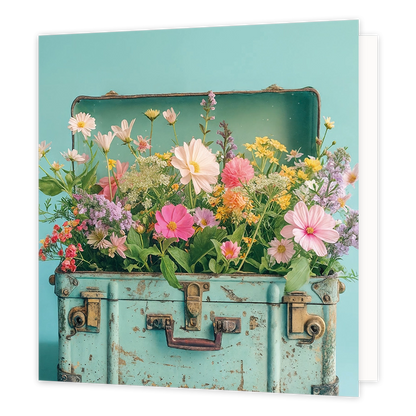 Koffer vol bloemen - Formaat: Standaard - Vorm: Vierkant - Blanco kaart - Op deze wenskaart staat een illustratie van een oude, lichtblauwe koffer die tot de rand toe gevuld is met een kleurrijke mix van diverse veldbloemen en zomerbloemen in zachte tinten zoals roze, geel en wit. De koffer heeft een vintage uitstraling met messingkleurige details en slijtageplekken, en staat afgebeeld tegen een effen lichtblauwe achtergrond. Er is geen tekst op de illustratie zichtbaar. - Snelwenskaart