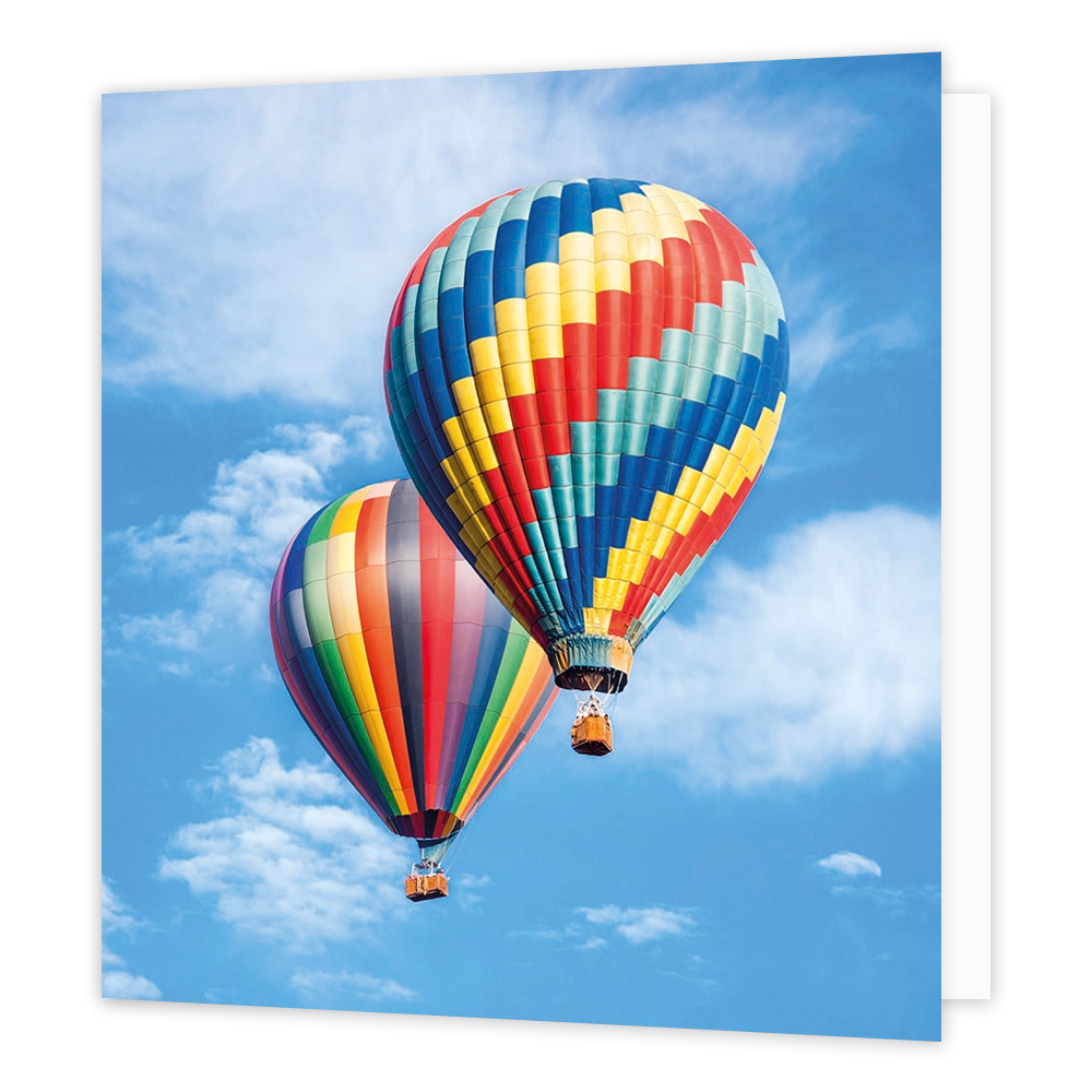 Luchtballonnen - Formaat: Standaard - Vorm: Vierkant - Blanco kaart - Op deze wenskaart staat een illustratie van twee kleurrijke hete-luchtballonnen die vliegen tegen een helderblauwe lucht met witte wolken. De ballon op de voorgrond is gedecoreerd met een zigzaggend patroon in diverse kleuren, terwijl de ballon erachter verticale banen in regenboogkleuren heeft. Onder beide ballonnen hangt een kleine mand. Er is geen tekst op de illustratie zichtbaar. - Snelwenskaart