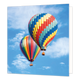 Luchtballonnen - Formaat: Standaard - Vorm: Vierkant - Blanco kaart - Op deze wenskaart staat een illustratie van twee kleurrijke hete-luchtballonnen die vliegen tegen een helderblauwe lucht met witte wolken. De ballon op de voorgrond is gedecoreerd met een zigzaggend patroon in diverse kleuren, terwijl de ballon erachter verticale banen in regenboogkleuren heeft. Onder beide ballonnen hangt een kleine mand. Er is geen tekst op de illustratie zichtbaar. - Snelwenskaart