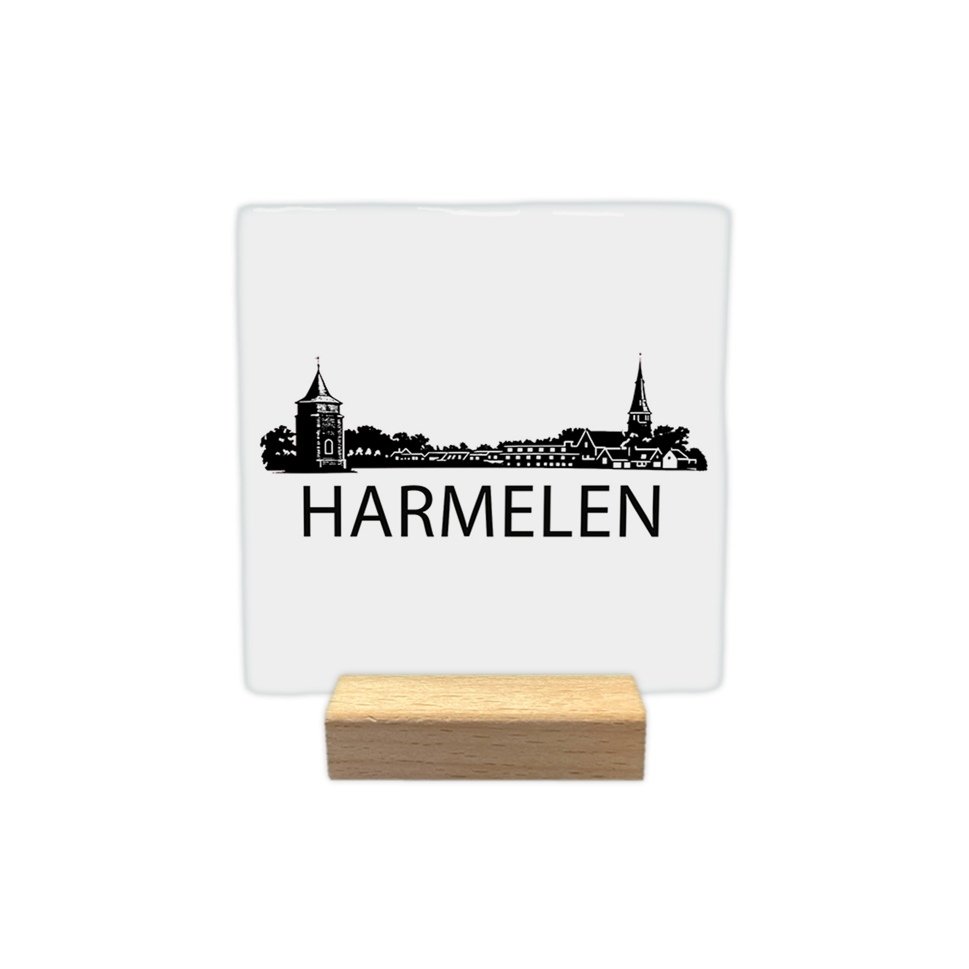 Harmelen skyline - Decoratie tegel - Formaat: - Op deze decoratie tegel staat een zwarte skyline van Harmelen afgebeeld tegen een witte achtergrond. Het silhouet bevat diverse gebouwen, waaronder een opvallende toren en een kerktoren. Onder het silhouet staat in zwarte letters de plaatsnaam Harmelen. Het ontwerp is uitgevoerd in een gedetailleerde zwart-witstijl. - Snelwenskaart