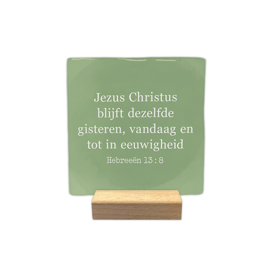 Hebreeën 13:8 - Decoratie tegel - Formaat: - Op deze decoratie tegel staat de tekst "Jezus Christus blijft dezelfde gisteren, vandaag en tot in eeuwigheid" in witte letters. Daaronder wordt de bijbeltekst "Hebreeën 13:8" vermeld. Het geheel is geplaatst tegen een zachtgroene achtergrond die een vlekkerig effect heeft. - Snelwenskaart