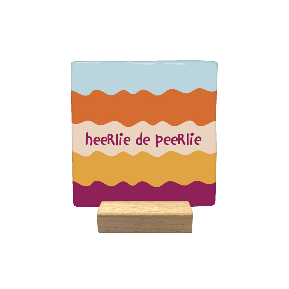 Heerlie de peerlie - Decoratie tegel - Formaat: - Op deze decoratietegel staat de tekst "heeRlie de peeRlie" in donkerpaarse, speelse letters centraal afgebeeld. De achtergrond bestaat uit horizontale, golvende banen in diverse kleuren, waaronder lichtblauw, oranje, beige, geel en donkerpaars. - Snelwenskaart