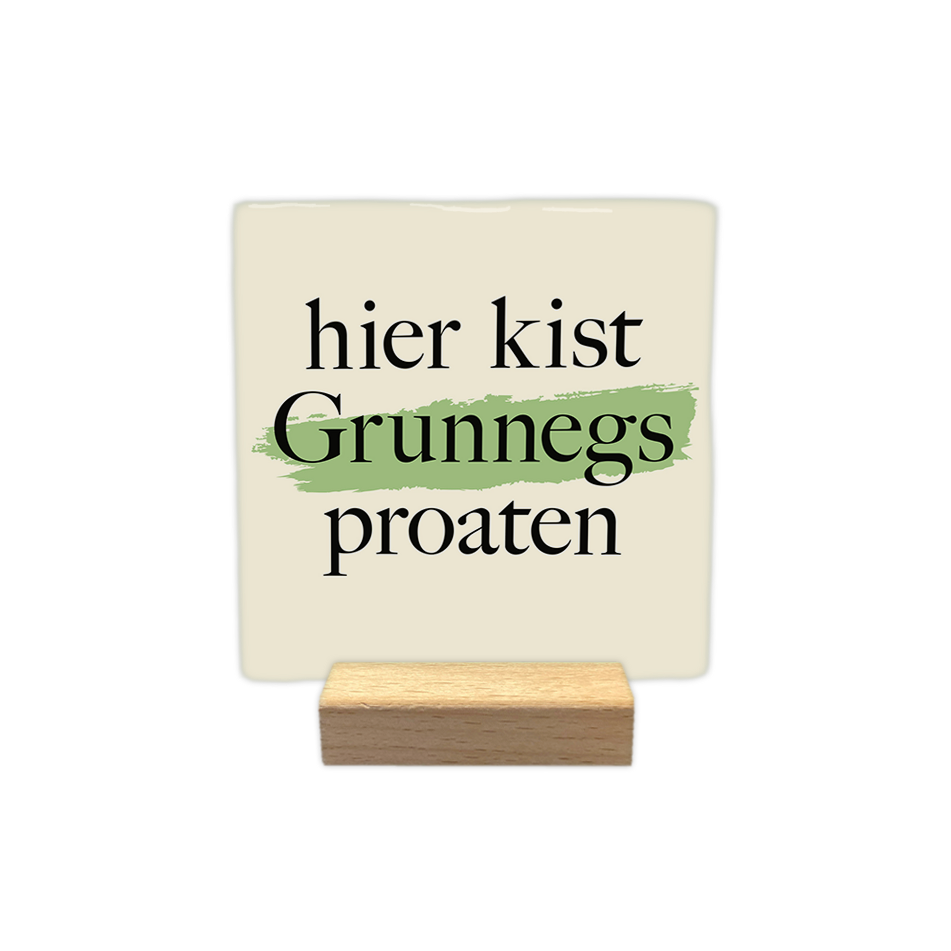 Hier kist Grunnegs proaten - Decoratie tegel - Formaat: - Op deze decoratie tegel staat de tekst "hier kist Grunnegs proaten" in zwarte letters centraal afgebeeld. Achter het woord "Grunnegs" loopt een horizontale, lichtgroene verfstreep. De achtergrond van de tegel is lichtbeige van kleur. - Snelwenskaart