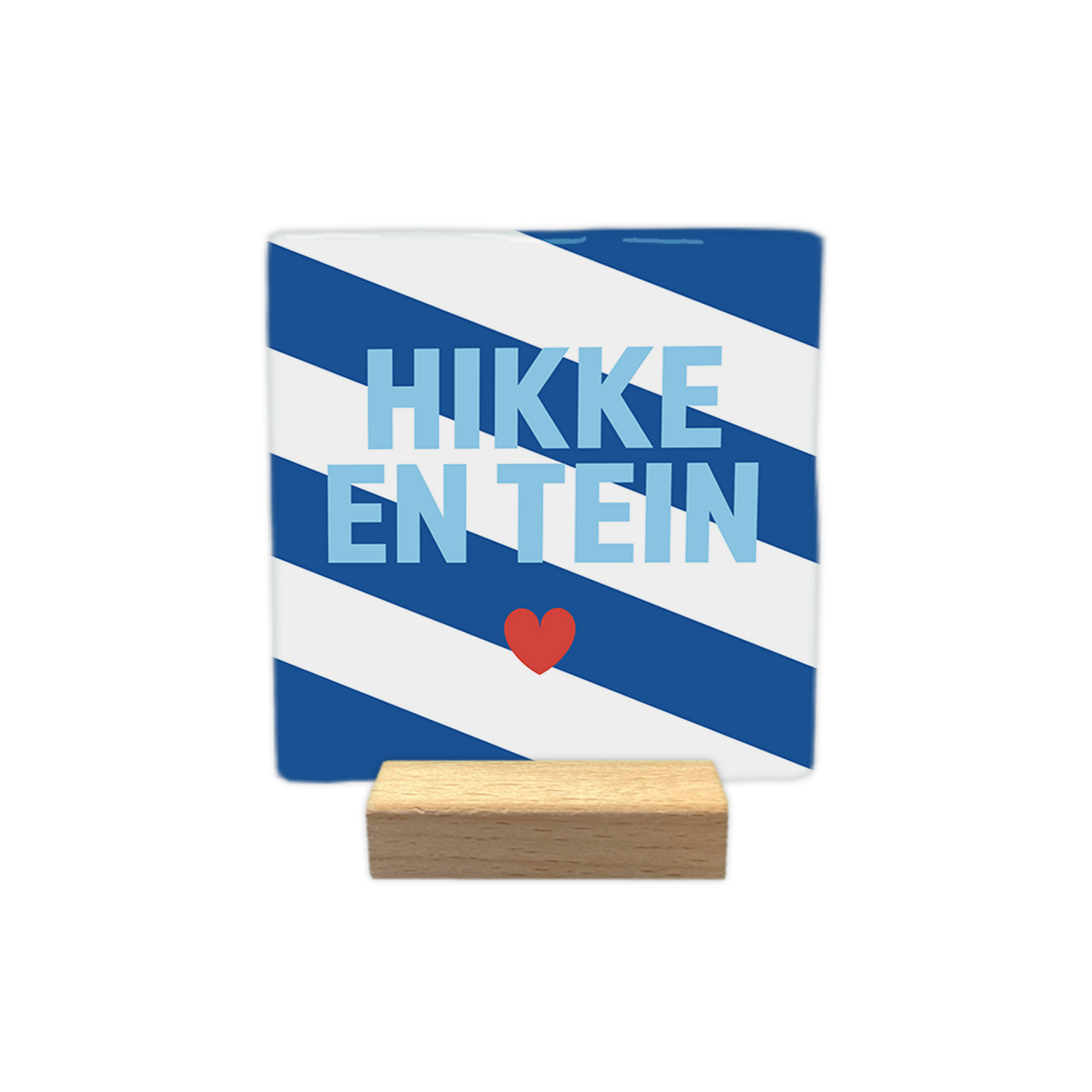 Hikke en tein - Decoratie tegel - Formaat: - Op deze decoratie tegel staat de tekst "HIKKE EN TEIN" in lichtblauwe letters centraal afgebeeld. Onder de tekst is een klein rood hartje geplaatst. De achtergrond van de tegel bestaat uit schuin lopende blauwe en witte banen. - Snelwenskaart