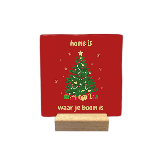 Home is waar je boom is - Decoratie tegel - Formaat: - Op deze decoratie tegel staat een rode achtergrond met een versierde kerstboom in het midden. Onder de boom liggen verschillende cadeautjes en eromheen zijn kleine sterren getekend. Boven en onder de boom staat in gele letters de tekst: home is waar je boom is. - Snelwenskaart