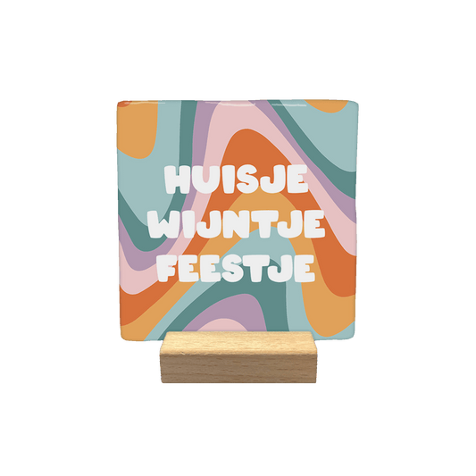 Huisje wijntje feestje - Decoratie tegel - Formaat: - Op deze decoratietegel staat centraal de tekst "HUISJE WIJNTJE FEESTJE" in dikke, witte letters afgebeeld. De achtergrond wordt gevormd door een kleurrijk, golvend patroon in tinten oranje, roze, paars en blauw. - Snelwenskaart