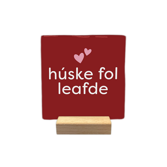 Húske fol leafde - Decoratie tegel - Formaat: - Op deze decoratie tegel staat de tekst "húske fol leafde" in witte letters centraal afgebeeld. Boven de tekst staan twee kleine, lichtroze hartjes. De achtergrond van de tegel is dieprood van kleur. - Snelwenskaart