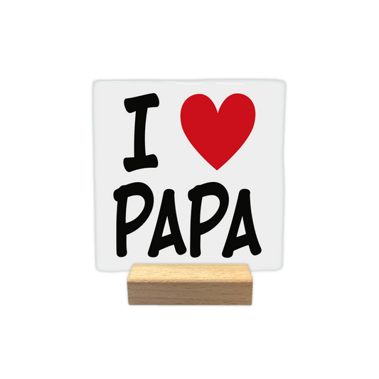 I love papa - Decoratie tegel - Formaat: - Op deze decoratie tegel staat de tekst "I" naast een rood hartje, dat de functie van het woord "LOVE" vervult. Daaronder staat het woord "PAPA" geschreven in grote, zwarte hoofdletters. Het ontwerp is gecentreerd en geplaatst op een witte achtergrond. - Snelwenskaart