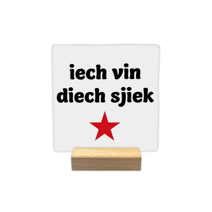 Ich vin dich sjiek - Decoratie tegel - Formaat: - Op deze decoratie tegel staat de tekst "iech vin diech sjiek" in zwarte letters afgebeeld tegen een witte achtergrond. Onder de tekst is een rode, vijfpuntige ster geplaatst. Het ontwerp is eenvoudig en strak vormgegeven. - Snelwenskaart