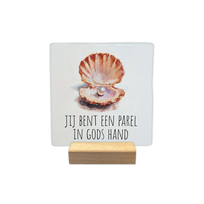 Jij bent een parel - Decoratie tegel - Formaat: - Op deze decoratie tegel staat een schildering van een geopende schelp met een parel erin. Daaronder staat de tekst "Jij bent een parel in Gods hand" in zwarte letters. Het geheel is geplaatst tegen een lichte, effen achtergrond. - Snelwenskaart
