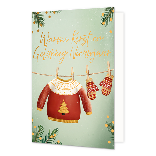 Warme kerst en gelukkig nieuwjaar - Formaat: Standaard - Vorm: Staand - Kerstkaart - Op deze wenskaart hangen een rode kersttrui en twee bijpassende wanten met houten knijpers aan een waslijn. De trui is versierd met een gouden kerstboom op de borst en een wit patroon met hartjes bij de hals. De achtergrond heeft een zachte groene kleur, omlijst met dennentakken en gouden stippen. Bovenaan de illustratie staat de gele, handgeschreven tekst "Warme Kerst en Gelukkig Nieuwjaar". - Snelwenskaart