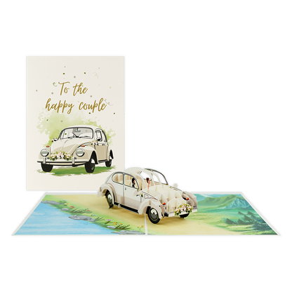 To the happy couple - Formaat: Standaard - Vorm: Staand - Huwelijkskaart - Op deze wenskaart staat een witte trouwauto met daarboven de tekst: "To the happy couple". - Snelwenskaart