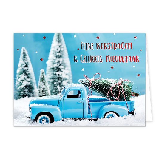 Fijne kerstdagen & gelukkig nieuwjaar - 8 stuks - Formaat: Normaal - Vorm: Liggend - Kerstkaart - Op deze wenskaart staat een sfeervolle afbeelding van een lichtblauwe oldtimer pick-up truck die door een dik pak sneeuw rijdt. In de laadbak van de truck ligt een besneeuwde kerstboom, vastgebonden met een rood-wit gestreept touw. De achtergrond toont een winters landschap met wazige, besneeuwde dennenbomen onder een helderblauwe lucht die versierd is met kleine rode en witte sterretjes. Rechtsboven staat de 