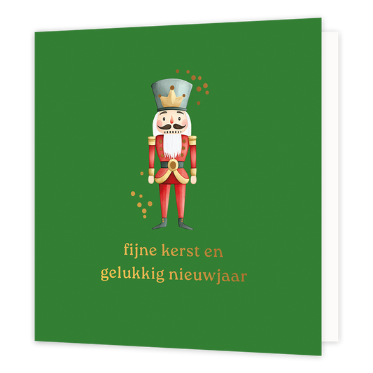 Op deze wenskaart staat een klassieke illustratie van een notenkraker in een traditioneel rood uniform met goudkleurige accenten en een grijze hoed met een kroontje. De notenkraker wordt omringd door subtiele, goudkleurige stipjes tegen een diepgroene achtergrond. Onderaan de kaart staat in elegante gouden letters de wens "fijne kerst en gelukkig nieuwjaar".