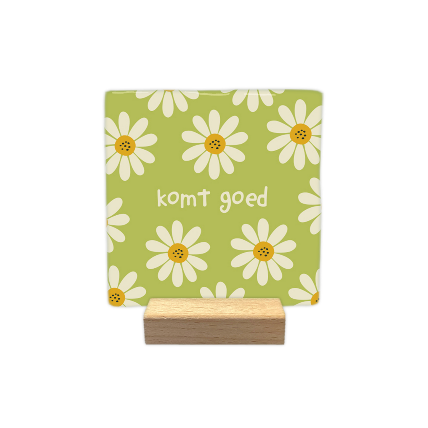 Komt goed - Decoratie tegel - Formaat: - Op deze decoratietegel staat centraal de tekst "komt goed" in kleine, witte letters afgebeeld. De achtergrond heeft een lichtgroene kleur en is bedekt met een patroon van witte bloemen met gele harten. - Snelwenskaart