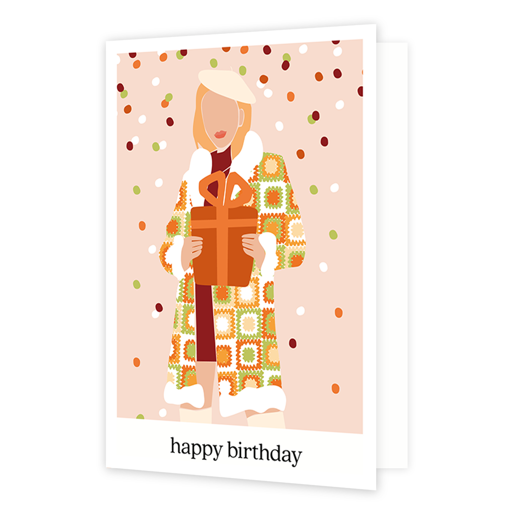 Happy birthday - Formaat: Normaal - Vorm: Staand - Verjaardagskaart - Op deze wenskaart staat een vrouw met een lange jas aan en een groot cadeau in haar handen. De achtergrond is zacht roze met groen, rood, oranje en witte sneeuwval. De afbeelding staat in een witkader en onderin staat de tekst 'happy birthday'. - Snelwenskaart