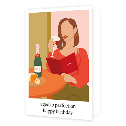 Aged to perfection happy birthday - Formaat: Standaard - Vorm: Staand - Verjaardagskaart - Op deze wenskaart staat een vrouw die een glas rode wijn drinkt terwijl ze op de wijnkaart kijkt. Onder de illustratie staat de tekst: "Aged to perfection happy birthday". - Snelwenskaart