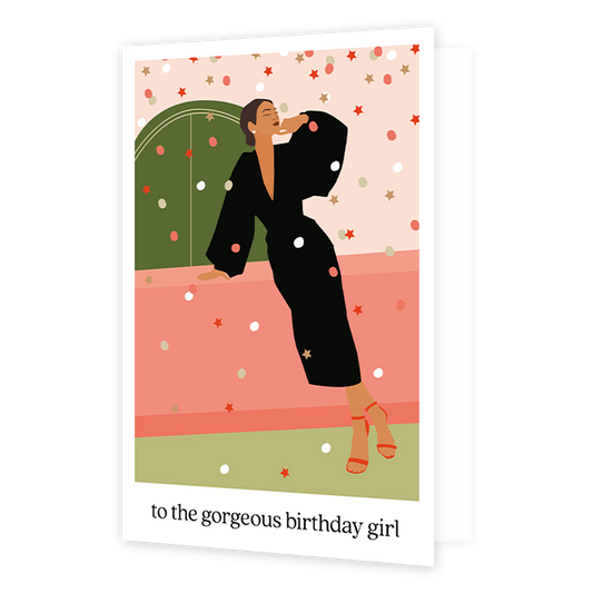 To the gorgeous birthday girl - Formaat: Normaal - Vorm: Staand - Verjaardagskaart - Op deze wenskaart staat een vrouw in een zwarte jurk die op een roze tafel leunt. Onder de illustratie staat de tekst: "To the gorgeous birthday girl". - Snelwenskaart
