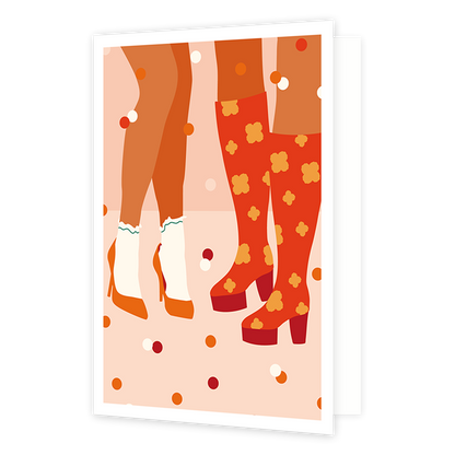 Op deze wenskaart staan twee paar benen. Het ene paar draagt witte sokken in combinatie met lage, oranje hakken. Het andere paar is afgebeeld met hoge rode hakken, voorzien van een oranje bloemmotief.