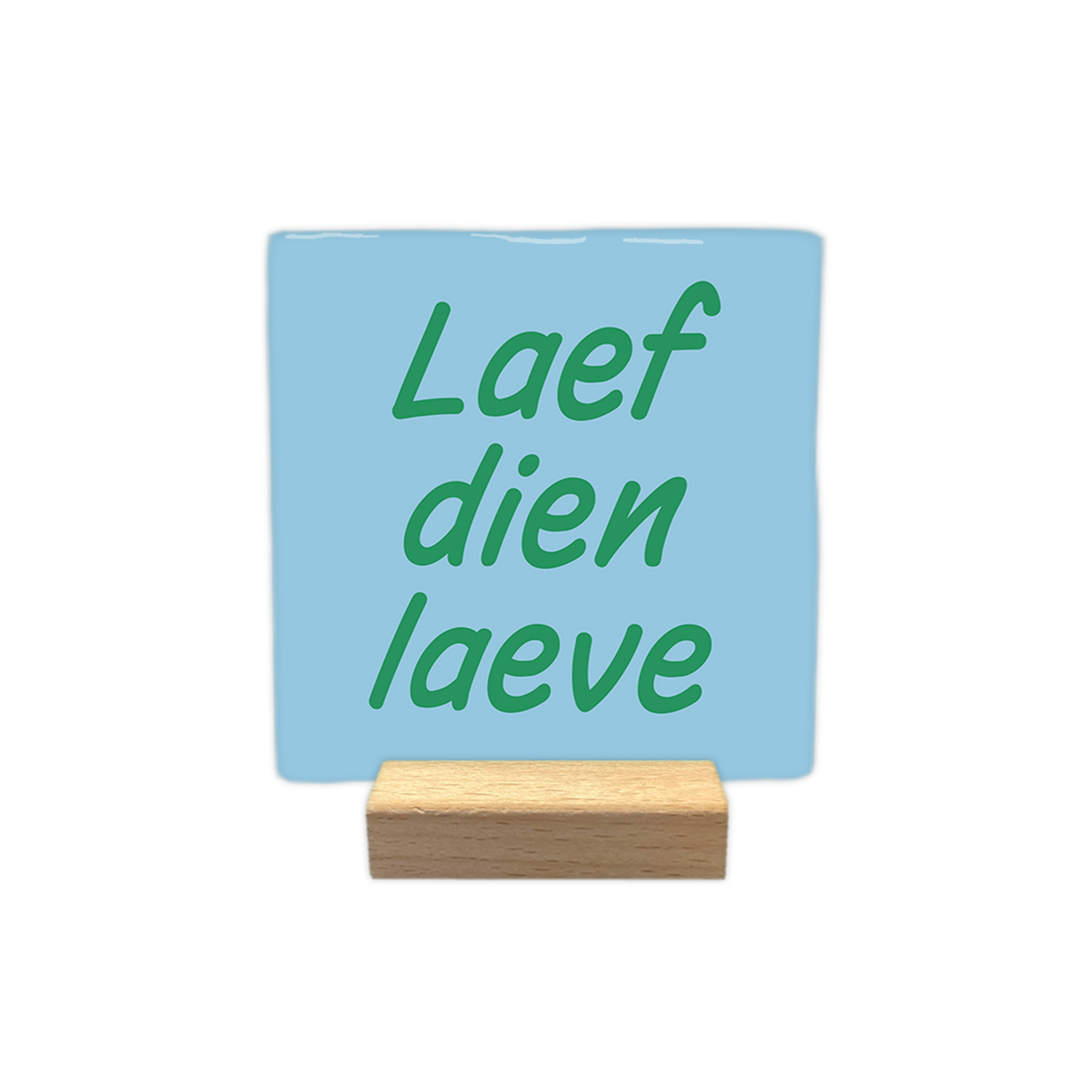 Laef dien laeve - Decoratie tegel - Formaat: - Op deze decoratie tegel staat de tekst "Laef dien laeve" in groene letters. De tekst is verdeeld over drie regels en geplaatst op een lichtblauwe achtergrond. Het gebruikte lettertype is cursief en heeft een vriendelijke, informele uitstraling. - Snelwenskaart