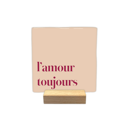 L'amour toujours - Decoratie tegel - Formaat: - Op deze decoratie tegel staat de tekst l'amour toujours in rode letters gedrukt. De achtergrond van de tegel heeft een lichte, beige tot roze kleur. - Snelwenskaart