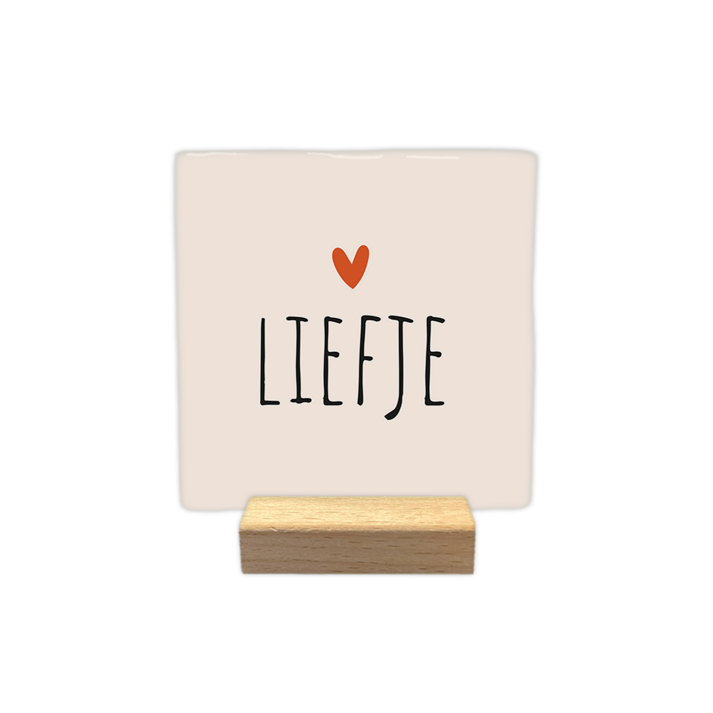 Liefje - Decoratie tegel - Formaat: - Op deze decoratie tegel staat de tekst "liefje" in zwarte letters afgebeeld. Boven de tekst bevindt zich een klein oranje hartje. De achtergrond van de tegel is lichtbeige van kleur. - Snelwenskaart