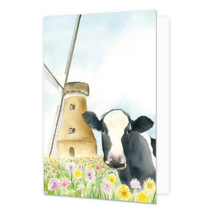 Op deze wenskaart staat een koe tussen de bloemen bij een molen.