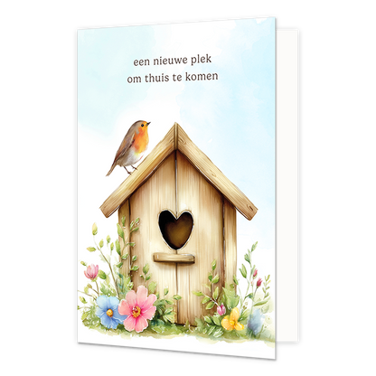 Op deze wenskaart staat een houten vogelshuisje met op het dak een roodborstje. Boven het vogelhuisje staat in het zwart de tekst 'een nieuwe plek om thuis te komen'.