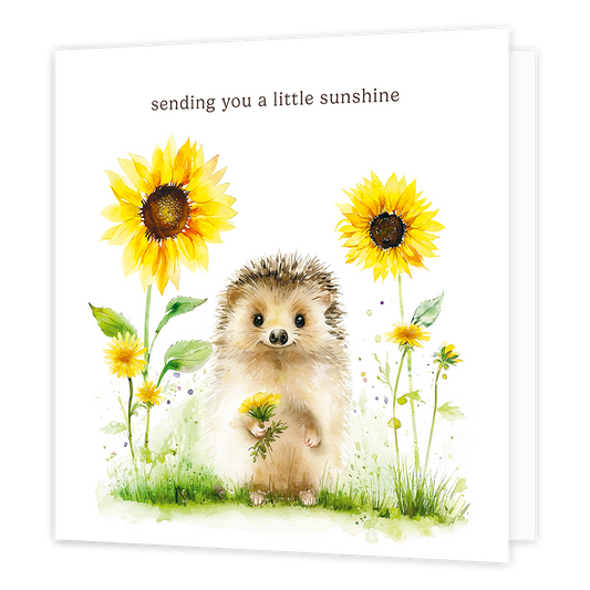 Sending you a little sunshine - Formaat: Groot - Vorm: Vierkant - Denken aan kaart - Op deze wenskaart staat een schattige egeltje afgebeeld op een witte achtergrond, dat in zijn pootjes een klein boeketje gele bloemen vasthoudt. Het egeltje staat in het gras en is omringd door grote zonnebloemen en kleinere gele bloemetjes in een aquarel-stijl. Bovenaan de afbeelding staat in bruine letters de tekst sending you a little sunshine. - Snelwenskaart
