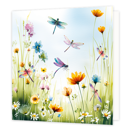 Bloemen en libellen - Formaat: Standaard - Vorm: Vierkant - Blanco kaart - Op deze wenskaart staat een levendige aquarelillustratie van een kleurrijk veld vol bloemen en grassen. Tussen de bloemen en in de lucht erboven vliegen meerdere libellen met doorschijnende, kleurrijke vleugels. De scène is uitgevoerd in een frisse en zonnige stijl met een lichtblauwe lucht op de achtergrond. - Snelwenskaart