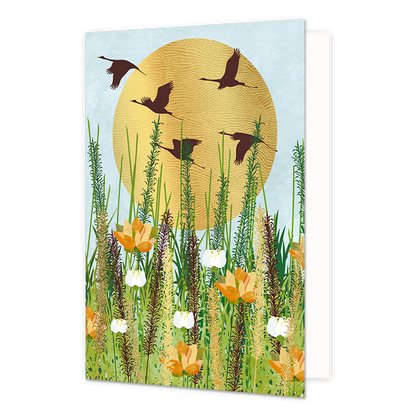Op deze wenskaart zie je een vijftal zwanen voor de zon vliegen. Op de voorgrond staan meedere planten. De maan bestaat uit goudfolie met textuur.